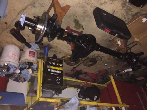 1994 Ford Bronco - A black rear axle assembly, likely from a truck or SUV, is shown disassembled in a garage setting.