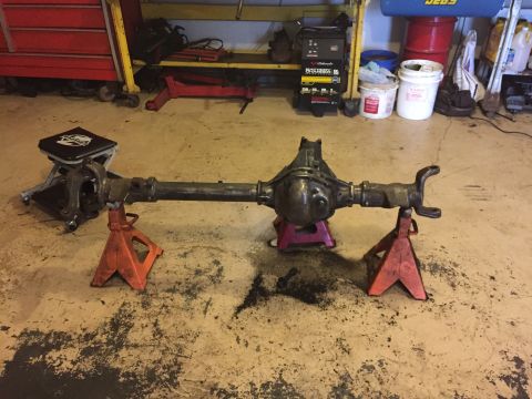 1994 Ford Bronco - A rear axle assembly is supported by jack stands in a workshop environment.