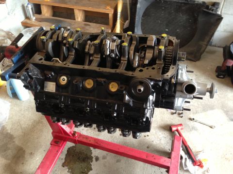 1994 Ford Bronco - Engine block assembly with crankshaft and connecting rods visible, mounted on a red engine stand.