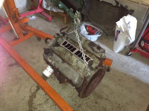 1994 Ford Bronco - Engine being lifted by a chain hoist in a garage setting.