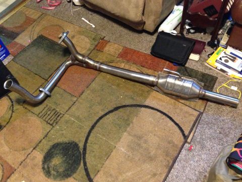 1994 Ford Bronco - A catalytic converter and exhaust pipe assembly is shown on a patterned rug.