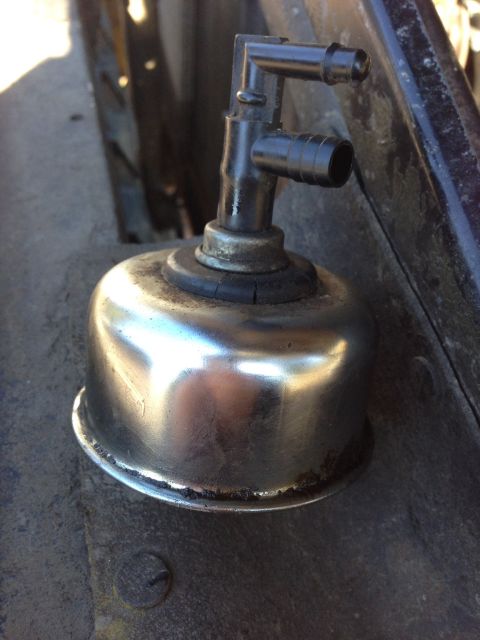 1979 Ford Bronco - Close-up of a chrome canister with black hoses, likely a part from a vehicle's engine bay.