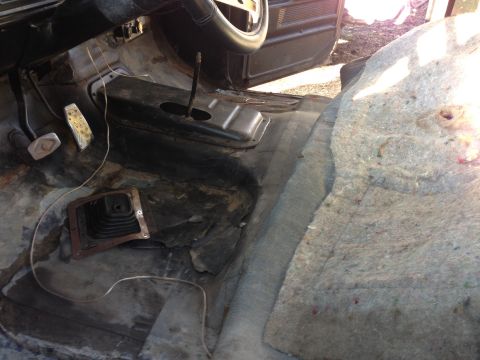 1979 Ford Bronco - The interior of a classic vehicle, likely a truck or SUV, shows a worn floor with exposed metal, a manual transmission shifter boot, and pe…