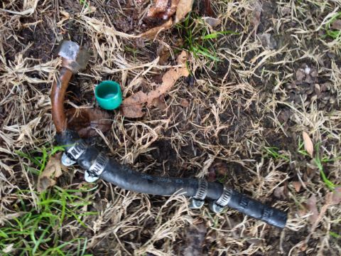 1979 Ford Bronco - A sprinkler head rests on the ground amidst dry vegetation.