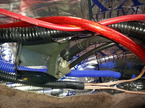 1994 Ford Bronco - Photo of red and blue power cables and a grounding lug bolted to chassis over foil sound-deadener.