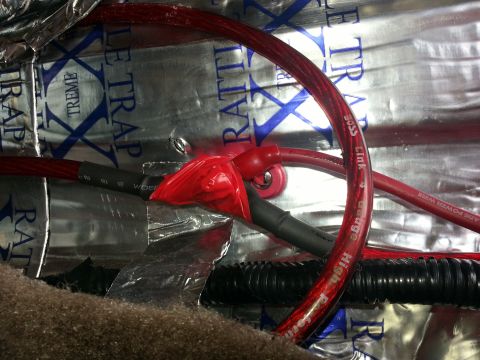 1994 Ford Bronco - Photo of a red audio power cable and distribution lug routed over RattleTrap foil sound-deadener.
