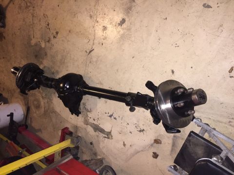 1994 Ford Bronco - A black painted Ford Bronco rear axle assembly with disc brakes is shown on a concrete floor.