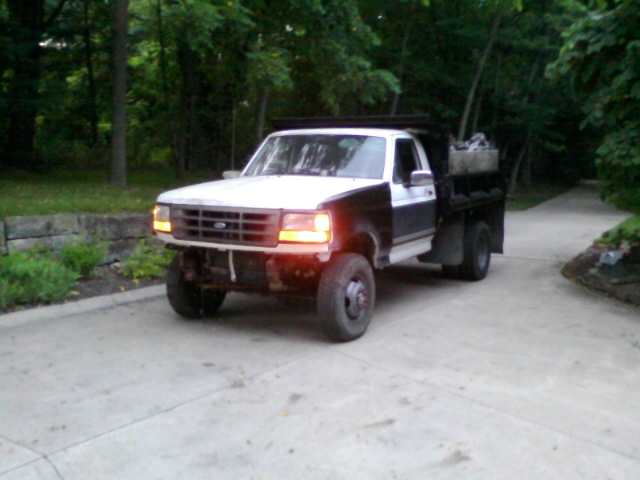 1989 Ford F-350 dump truck, white and black, parked on a driveway.