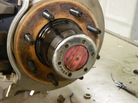 1979 Ford Bronco - A close-up view of a rusty hub assembly with a red and silver locking mechanism on a vehicle. The words "LOCK" and "FREE" are visible on th…