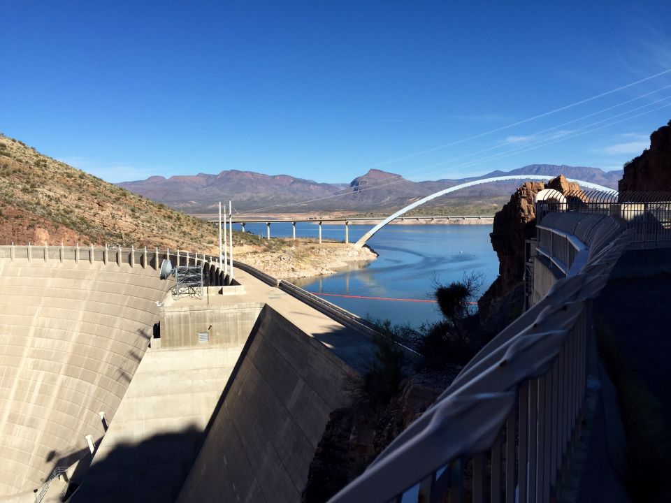 Dam and lake with a bridge in the background.