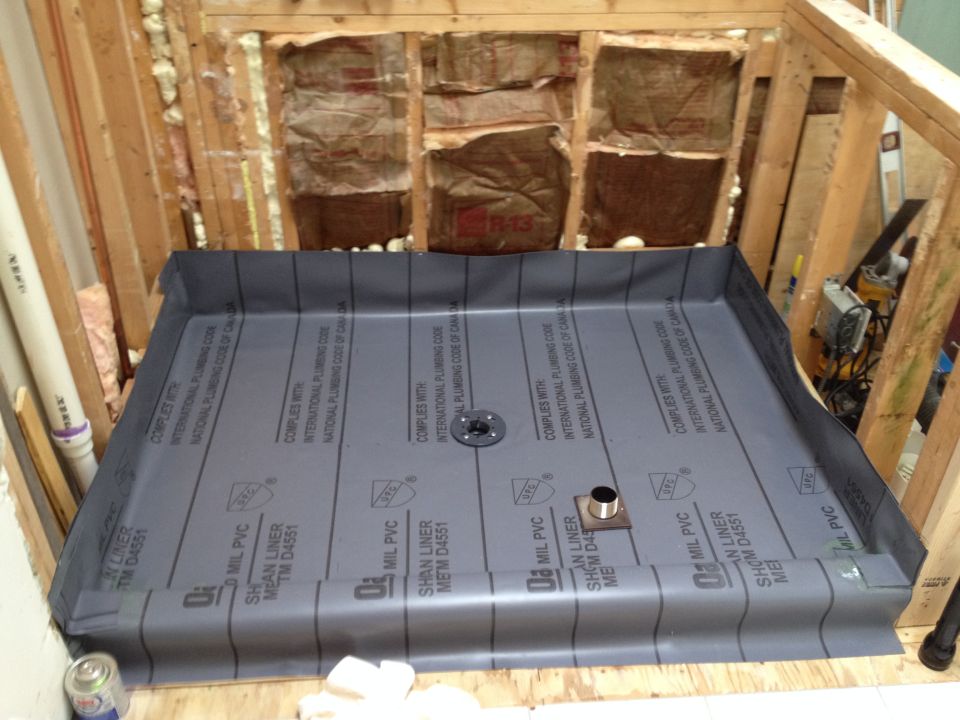 Shower pan liner installed in a wooden framed shower stall construction.