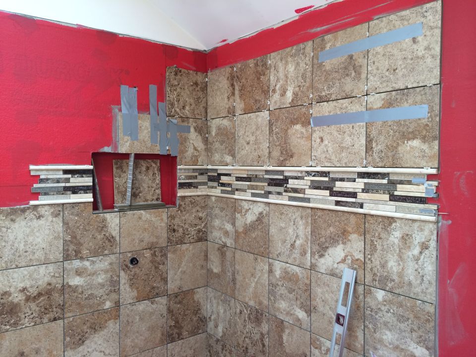 Bathroom shower stall under construction with tile work in progress.
