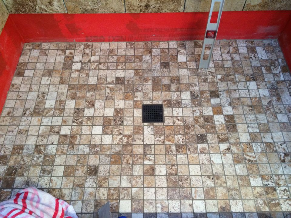 Shower floor with mosaic tile, drain, and level