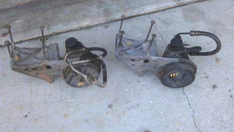 1994 Ford Bronco - Two power steering pumps are shown, each with a mounting bracket and hoses attached.