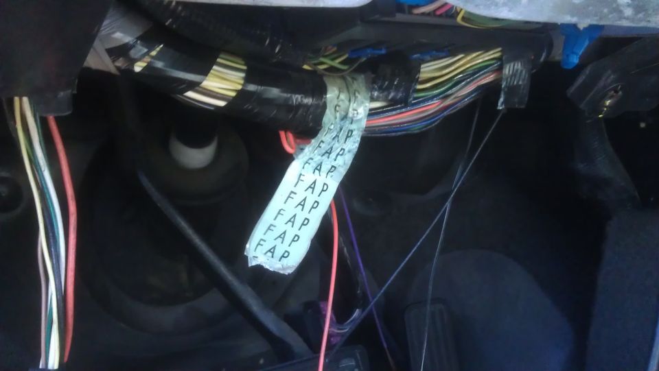 Close-up of a vehicle's wiring harness with a white tape label repeating 'FAP'