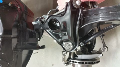 1970 Pontiac Trans Am - Close-up of a black front suspension component and disc brake assembly, likely during restoration or repair.