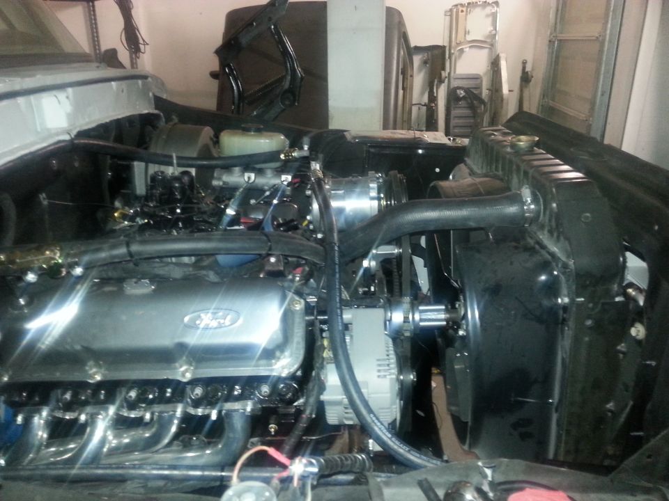 1979 Ford Bronco engine bay with V8 engine, chrome valve covers, headers, and radiator.