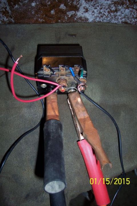 1973 Ford F-250 - A close-up view shows a black electrical relay with multiple wires connected to its terminals. Two large, insulated cables with copper ends…