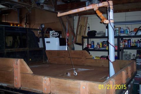 1973 Ford F-250 - The interior of a wooden truck bed with a small orange crane mounted above. A hook hangs from the crane into the bed.