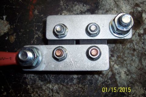 1973 Ford F-250 - Two aluminum battery terminal bus bars are shown mounted together, with one bar labeled "BAT". A red cable with "W-1" printed on it is atta…