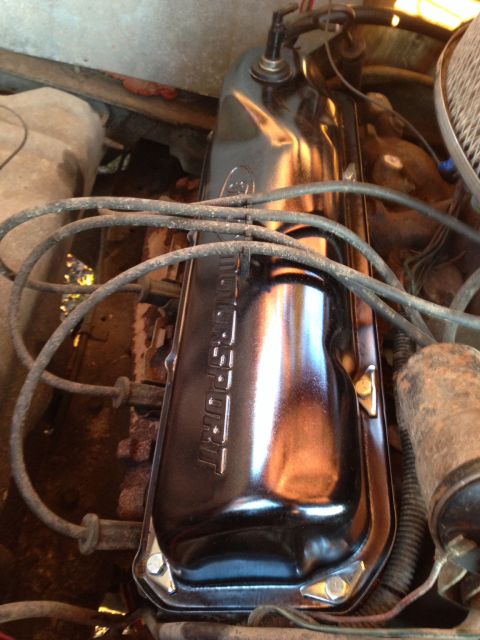 1979 Ford Bronco - A close-up view of a black Ford Motorsport valve cover on a V8 engine. Spark plug wires are routed over the cover, and a portion of the air…
