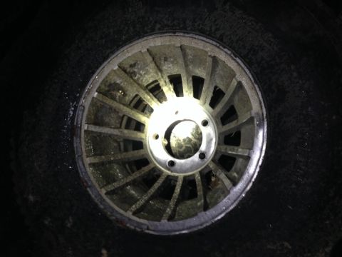 1979 Ford Bronco - A single, weathered alloy wheel is shown, with a prominent center hub and visible lug nut holes.