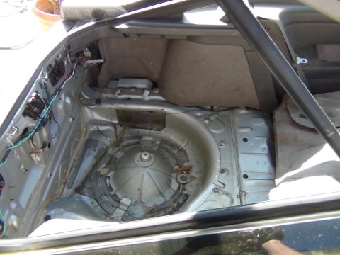 1991 Ford Probe - The trunk of a car is shown with the spare tire well exposed and some interior trim removed.