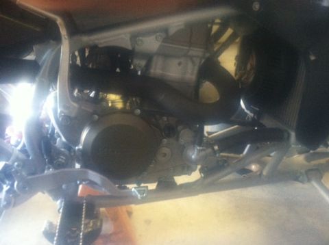 2005 Honda TRX 450 R - The engine and frame of a motorcycle are visible from a low angle, showing mechanical components.