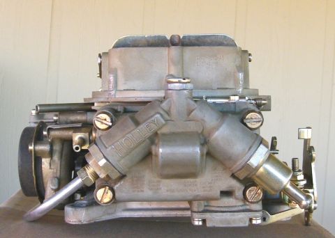 1968 Mercury Cougar - A metal Holley carburetor is shown in a close-up view, with visible branding and mechanical components.