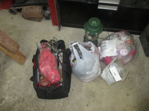 2004 Aston Martin Virage - Various tools and supplies are laid out on a concrete floor, including a green lantern and a black tool bag.
