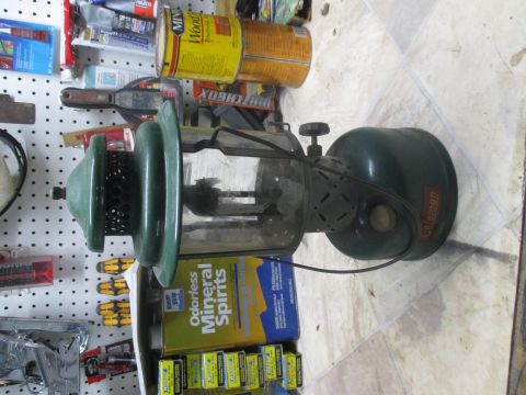 2004 Aston Martin Virage - Coleman lantern with glass globe and green metal casing, displayed on a pegboard wall.