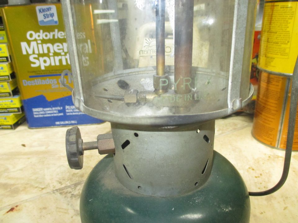 Close-up of a green lantern with a glass globe. "PYREX" and "MADE IN U.S.A." are visible on the metal base