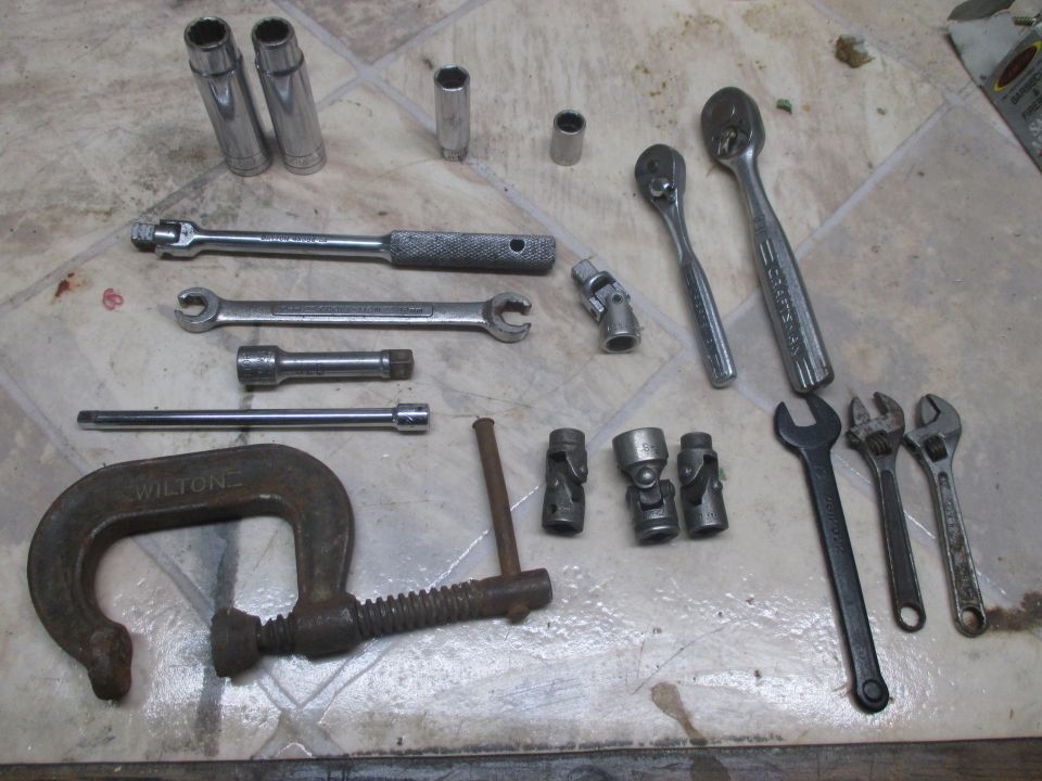 Assorted tools including sockets, wrenches, ratchets, and a C-clamp with 'WILTON' visible