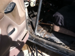 1995 Ford Bronco - Interior view of a vehicle's door jamb and floor, with visible wiring and a metal support bar.
