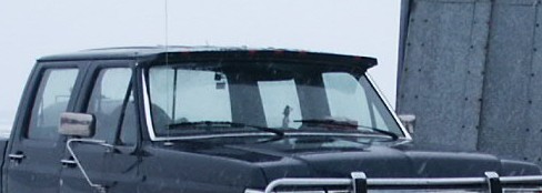 Black 1990 Ford Bronco truck, front-right view, with a chrome bumper and a sun visor