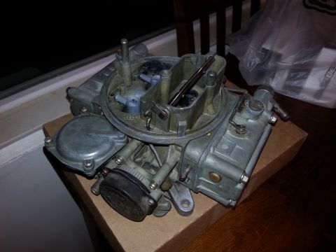1981 Ford Bronco - A close-up view of a carburetor, a critical engine component, is shown on a table.