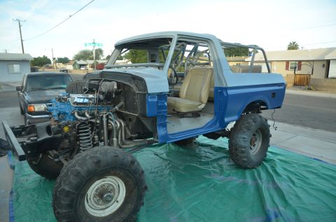 1979 Ford Bronco - This modified Ford Bronco, likely from the late 1970s, is undergoing restoration with its engine and interior partially visible.
