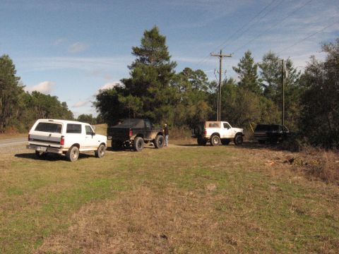 1994 Ford Bronco - Several SUVs are parked in a field, including a white 1987 Ford Bronco on the left.