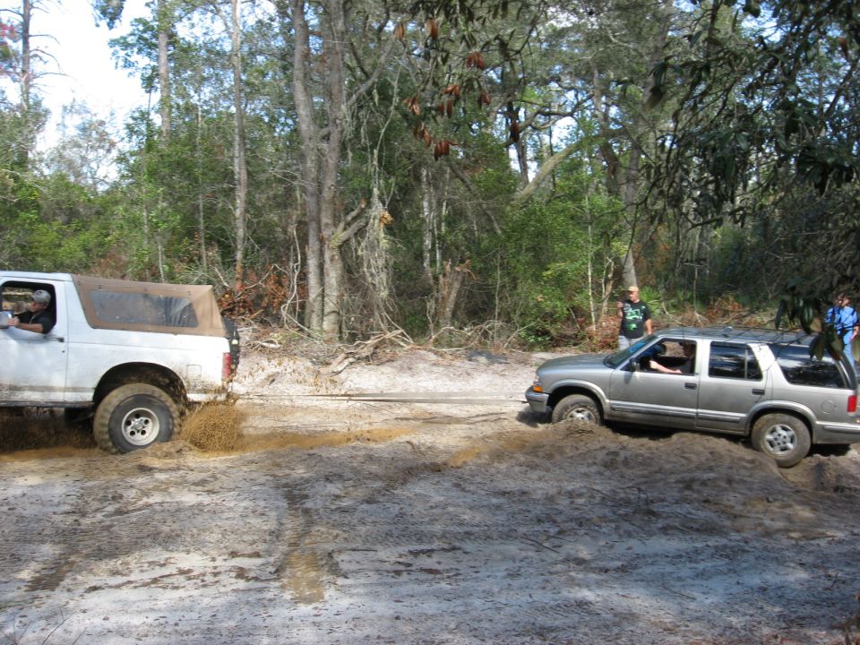 Silver SUV stuck in mud, white SUV behind it also stuck