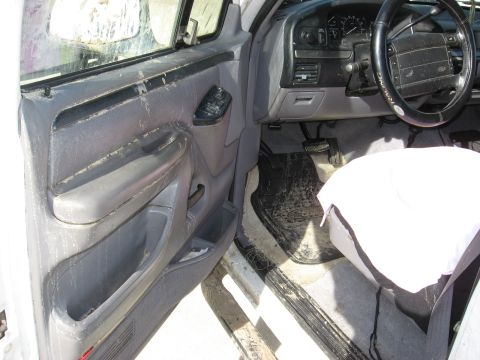 1994 Ford Bronco - The interior of this Ford truck shows significant wear and tear, with dirt covering the floor mats and upholstery.