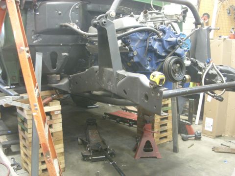 1967 Ford F-250 - Engine and frame assembly undergoing work, supported by various stands and jacks.