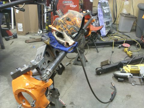 1967 Ford F-250 - A workshop scene with welding gear and a vehicle part undergoing work.