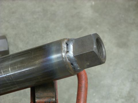 1967 Ford F-250 - Close-up of a metal pipe with a welded hex fitting, likely a component for a larger assembly.