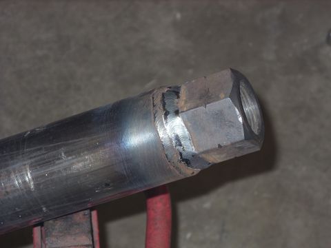 1967 Ford F-250 - A metal pipe with a welded hex nut is shown against a concrete background.