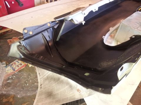 1976 Ford Ranchero - A close-up view of a black metal automotive part, likely from the undercarriage or fender area.