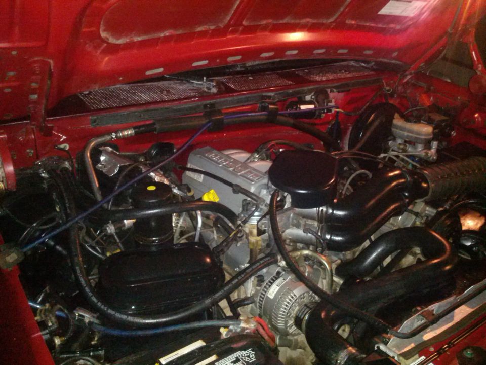 Red engine bay with V8 engine components visible