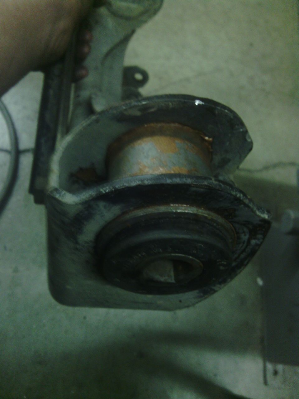 Close-up of a rusty suspension part with a rubber bushing