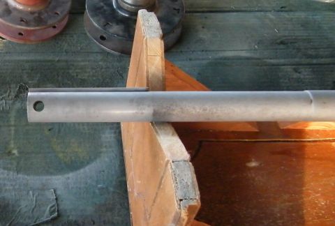 1909 Ford Model T - A metal rod is supported by wood, with other metal parts in the background.