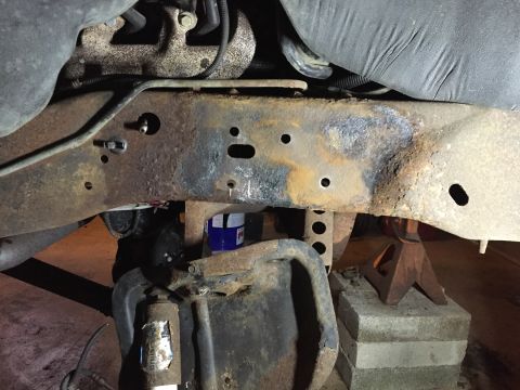 1994 Ford Bronco - Heavily rusted vehicle frame and suspension components are visible, supported by jack stands.