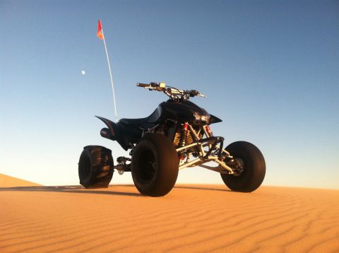 2005 Honda TRX 450 R - An ATV sits on a sand dune, its red flag fluttering in the breeze.